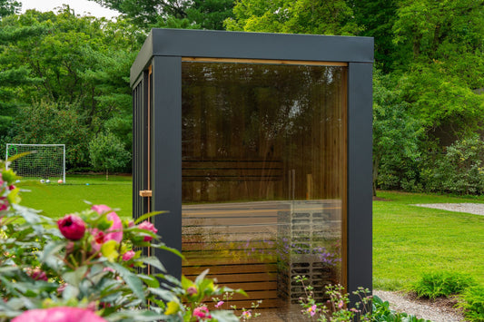 Neptune Mini glass front sauna surrounded by flowers